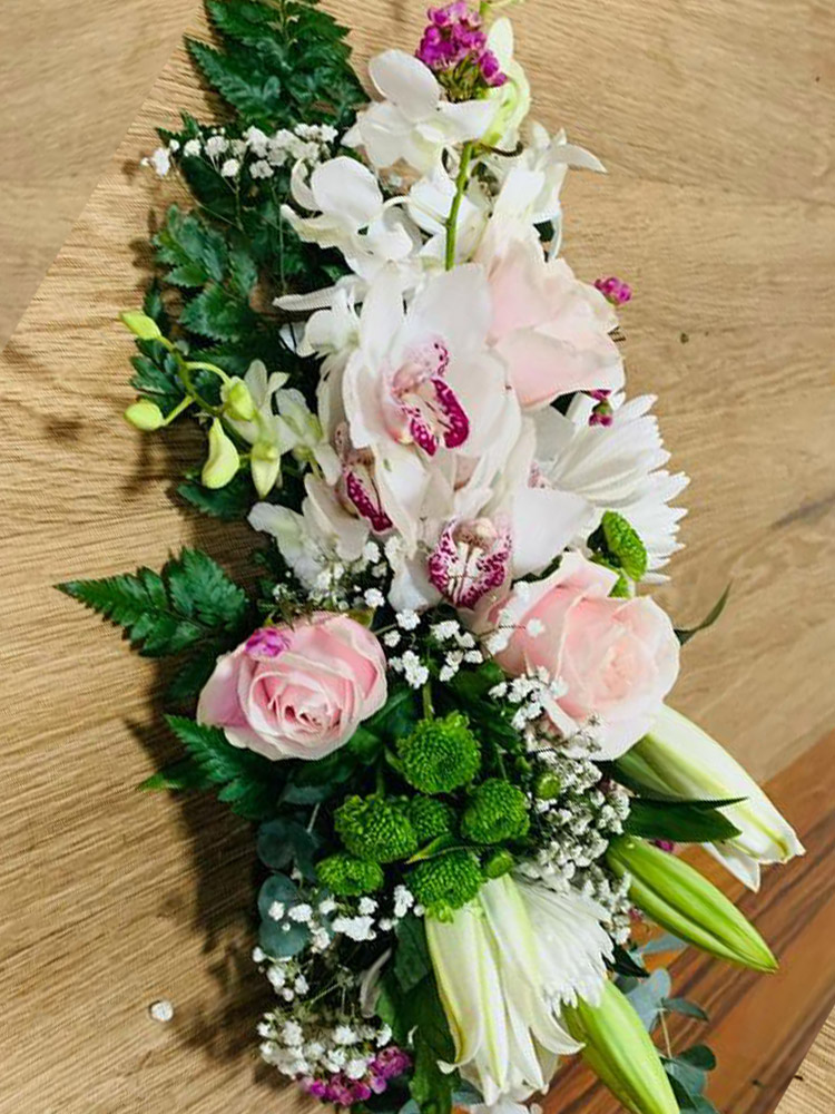 Centre de table, floral élégant avec orchidées blanches, roses roses et lys, agrémenté de gypsophile et verdure.