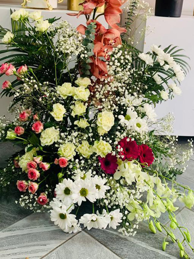 bouquet naissance Dakar, orchidées corail Sénégal, fleurs tendres à offrir, composition florale pastel, livraison fleurs Sénégal, bouquet roses crème et marguerites, bouquet doux gypsophile