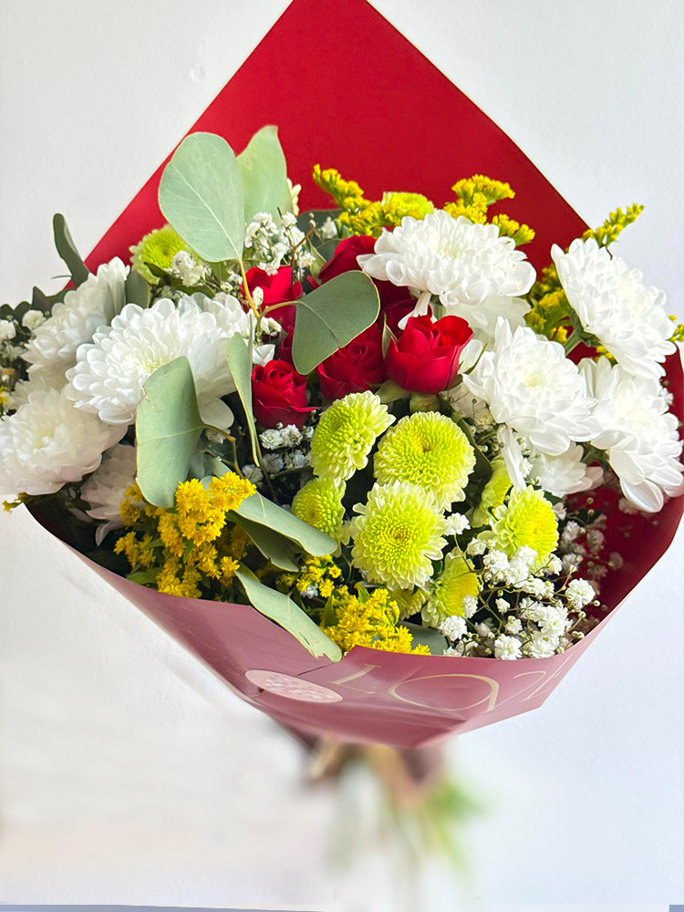 Bouquet de fleurs multicolores dans papier cadeau rouge et rose