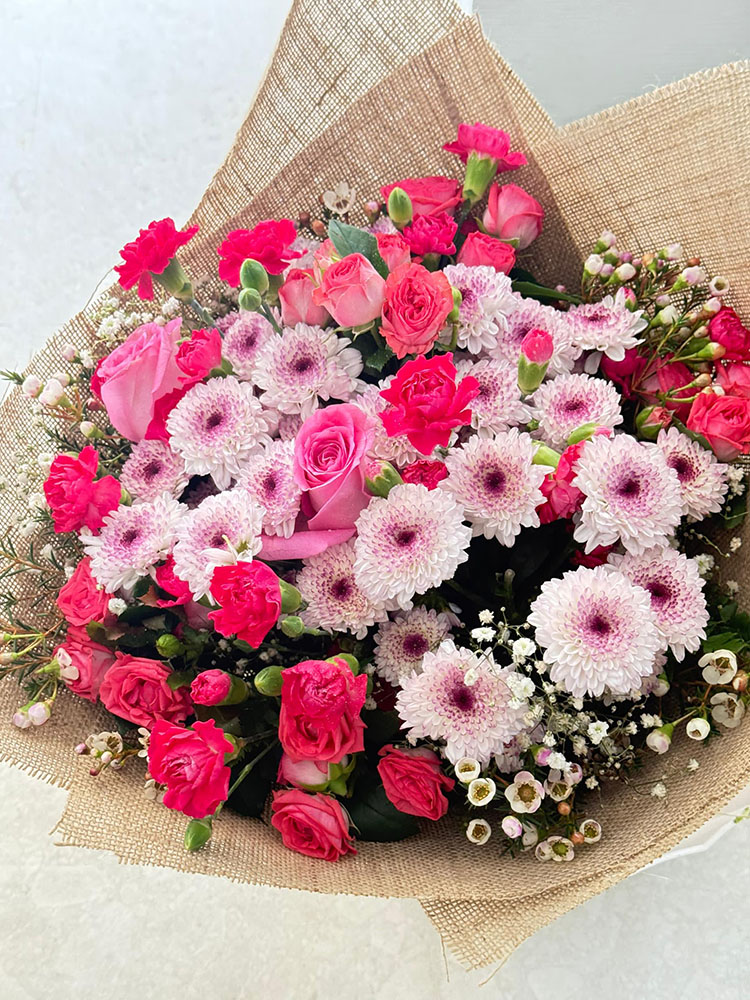 Cœur de Lumière, Bouquet rose et blanc gerberas, roses et œillets emballé en toile de jute