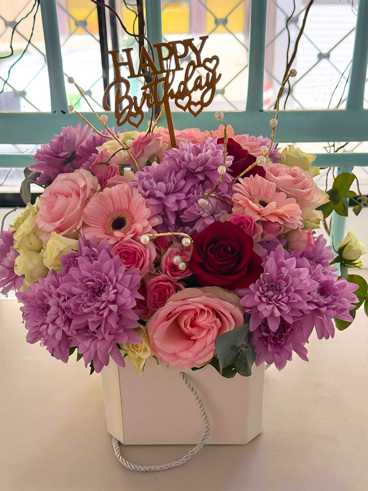 Fête en Couleurs, Bouquet de roses, dahlias, gerberas et lisianthus dans un vase