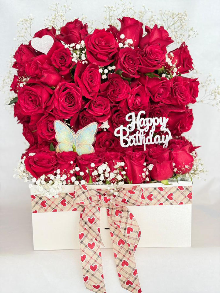 Rêve d’Iris, une biche des roses rouges luxe, gypsophile blanche, papillons et cœurs dans vase blanc