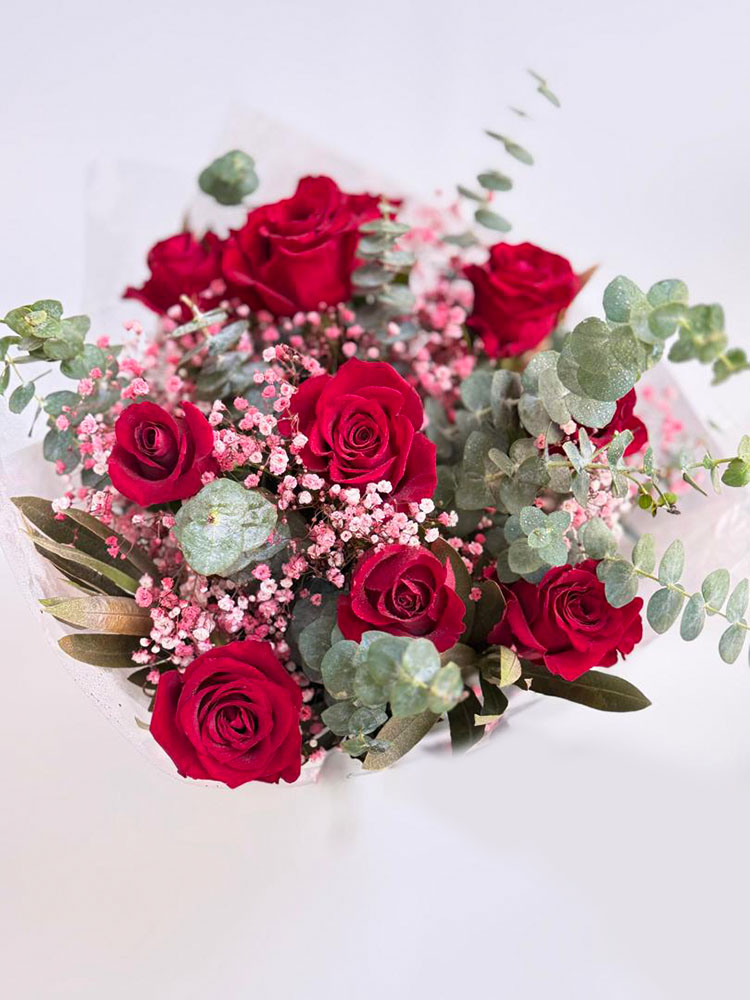 Bouquet de roses rouges avec gypsophile rose et feuilles d'eucalyptus